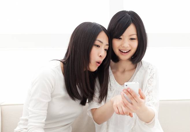스마트폰을 보며 대화를 나누는 젊은 여성들의 모습으로, 기사 내용과 직접적인 관련 없음. 123rf