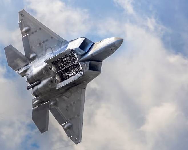 F-22 랩터 전투기가 내부 무장창을 연 채 비행하고 있다. 스텔스 전투기는 무장을 기체 내부에 탑재해 레이더 반사 신호를 줄이는 것이 핵심 설계 개념이다. 미 국방부 제공