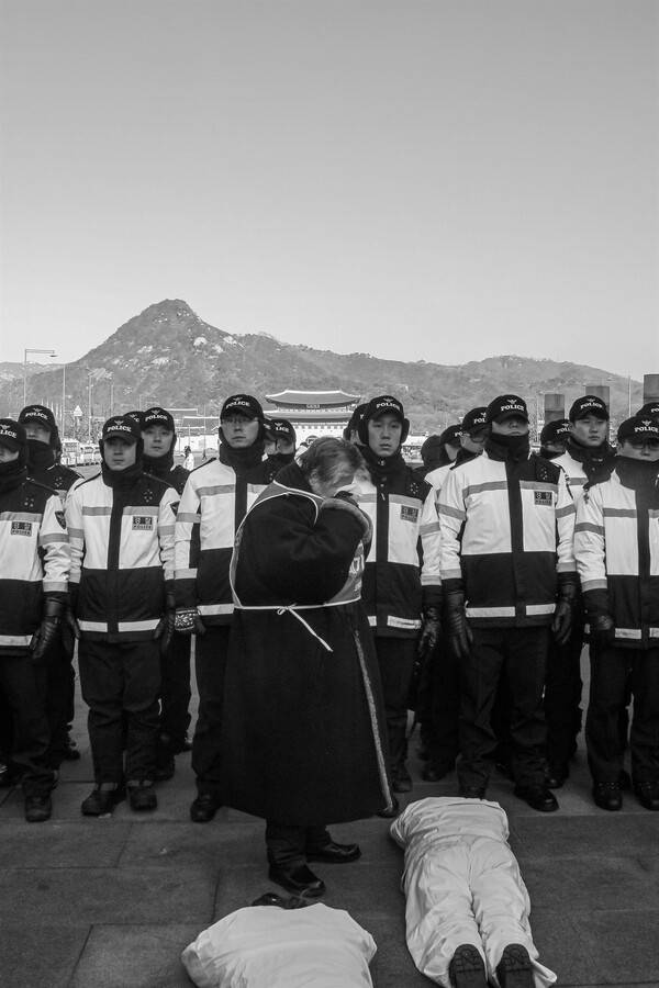 차가운 거리에서 마주한 대치의 풍경. 백기완 선생이 평생 서 있었던 '권력과 인간 사이의 경계선'을 상징하는 순간. 2014년 12월 광화문 광장이다. 정남준