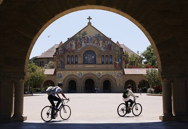 지난해 5월 30일(현지시간) 미국 캘리포니아주 스탠퍼드대학교 캠퍼스 내 메모리얼 교회 앞 메인 광장을 학생들이 자전거를 타고 지나가고 있다. EPA=연합뉴스