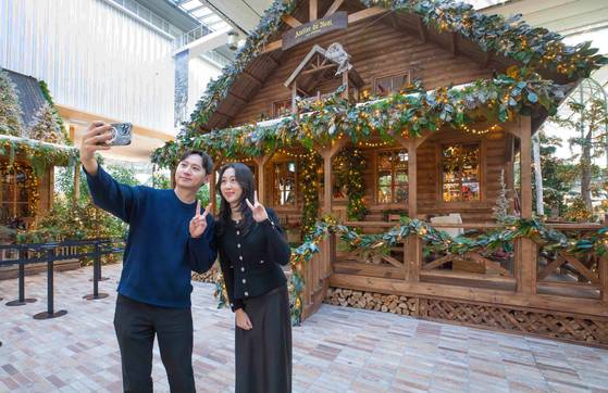 지난해 서울 영등포구 더현대 서울 5층 사운즈 포레스트에 조성된 '해리의 크리스마스 공방’에서 고객들이 기념 촬영하고 있는 모습. 사진 현대백화점그룹