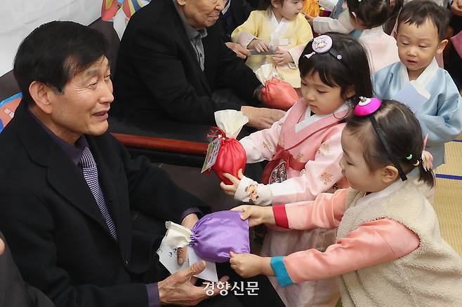 어린이들이 어르신들에게 세배를 한 뒤 떡을 전달하고 있다.