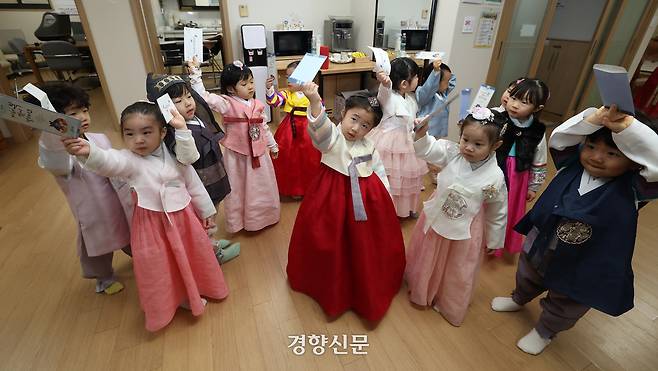 어린이들이  어르신들에게 세배를 한 뒤 세뱃돈이 든 봉투를 들어보이고 있다.