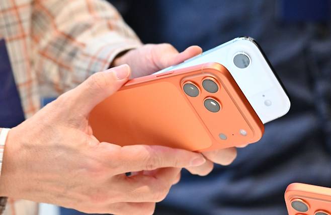 서울 중구 명동 애플스토어를 찾은 한 고객이 아이폰17 프로와 에어 제품을 비교하고 있다. [헤럴드DB]