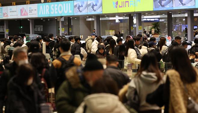 설 명절 연휴를 앞둔 11일 인천국제공항 제2여객터미널 출국장에서 승객들이 탑승 수속을 위해 줄을 서고 있다. [연합]