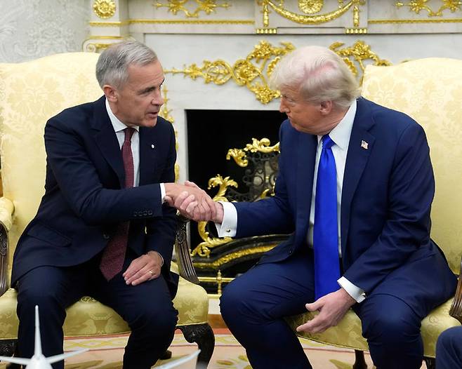 [워싱턴=AP/뉴시스] 도널드 트럼프(오른쪽) 미국 대통령이 지난해 10월 7일(현지 시간) 백악관 집무실에서 마크 카니 캐나다 총리와 회담 중 악수하고 있다. 2026.02.11.