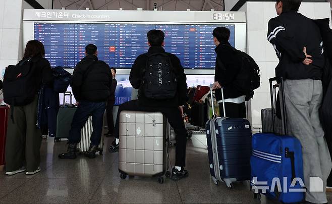 [인천공항=뉴시스] 이영환 기자 = 25일 오후 인천국제공항 제1여객터미널에서 여행객들이 출발편 안내를 살펴보고 있다.인천국제공항공사는 중국, 일본 노선 항공수요 증가세에 힘입어 2025년 여객실적 7407만 1475명, 운항실적 42만 5760회를 기록해 지난 2001년 개항이후 역대 최다 항공운송실적을 달성했다고 이날 밝혔다. 2026.01.25. 20hwan@newsis.com