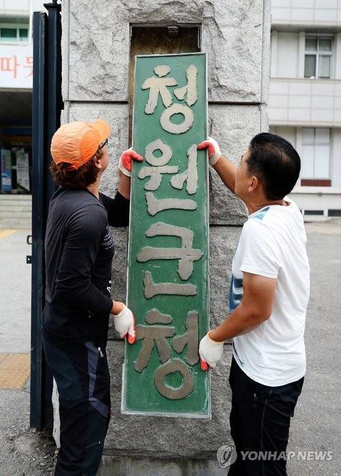 통합청주시 출범을 앞둔 충북 청원군이 2014년 6월26일 오전 청원군청 입구에서 '청원군청' 현판을 철거하는 모습[연합뉴스 자료사진]