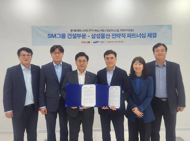 임동복 SM그룹 건설부문장(사장왼쪽 세 번째)과 이주용 삼성물산 건설부문 DxP사업부장(부사장왼쪽 네 번째)이 지난 11일 서울 서대문구 SM그룹 신촌사옥에서 홈플랫폼 홈닉(Homeniq)을 통한 스마트 주거 서비스 기술교류 협력을 위한 양해각서를 체결한 참석자들과 기념촬영을 하고 있다.(사진=SM그룹)