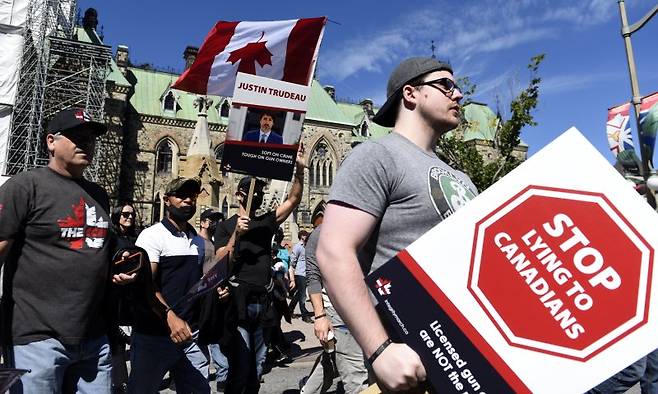 지난 2020년 9월 12일(현지 시간) 캐나다 오타와에서 총기 규제 강화에 반대하는 캐나다총기권리연합 주최 집회에 참가한 총기 권리 지지자들이 저스틴 트뤼도 당시 총리를 비판하는 팻말을 들고 있는 모습. 뉴시스