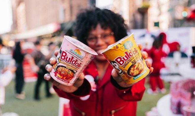 A participant holds Buldak noodles at Samyang Roundsquare’s Splash Buldak Noodle Exchange in Los Angeles, in November 2024. (Samyang Roundsquare)