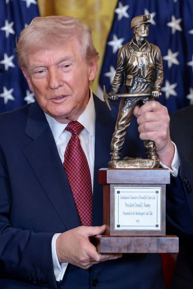 도널드 트럼프 미국 대통령이 11일(현지시간) 백악관에서 열린 석탄 관련 행사에서 석탄 챔피언 트로피를 받고 있다. 연합뉴스