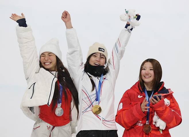 12일(현지시간) 이탈리아 리비뇨 스노파크에서 열린 2026 밀라노-코르티나담페초 동계올림픽 스노보드 여자 하프파이프 결승에서 금메달을 따낸 최가온이 기뻐하고 있다. 왼쪽은 은메달을 딴 미국 클로이 김, 오른쪽은 동메달 일본 오노 미쓰키./연합뉴스