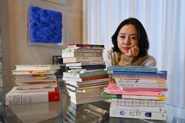 이소영 작가가 최근 출간한 '그림 읽는 밤' 등 자신의 저서와 일독을 추천하는 미술서를 보이고 있다. 미술계 N잡러인 그는 "할머니 때까지 미술 에세이스트로 살고 싶다"고 했다. 강예진 기자
