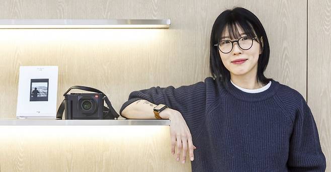 10년차 북튜버(책 추천 유투버)이자 작가인 김겨울 씨가 서울 중림동 한국경제신문사에서 첫 사진책 <모르는 채로 두기>와 자신의 라이카 카메라 옆에서 환하게 웃고 있다. 임형택 기자