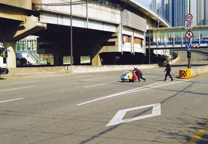 사진책을 닫는 두 장의 연작 사진 중 하나. 짐수레를 미는 노인과 뒤따르는 남자. 남자는 노인을 위해 무단횡단에 동참한 걸까.  세미콜론 제공