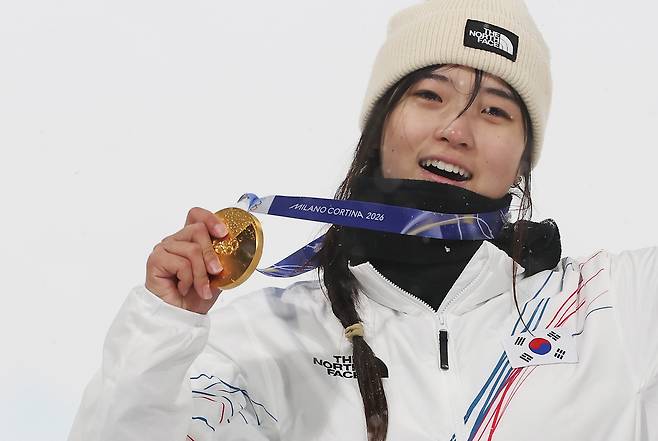 South Korean snowboarder Choi Gaon poses for a picture on the podium after winning gold in the women's halfpipe snowboarding event at the 2026 Milan-Cortina Olympics on Thursday. (Yonhap)