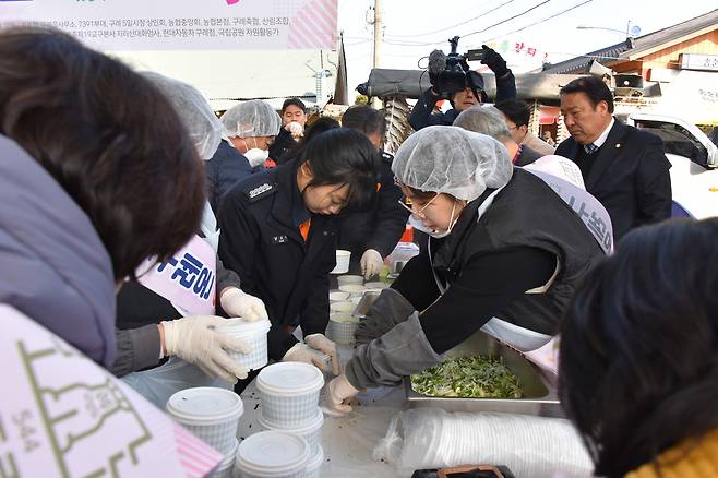 참석자들이 구례온 행사에서 떡국을 포장용기에 담고 있다. [사진=지리산 대화엄사]