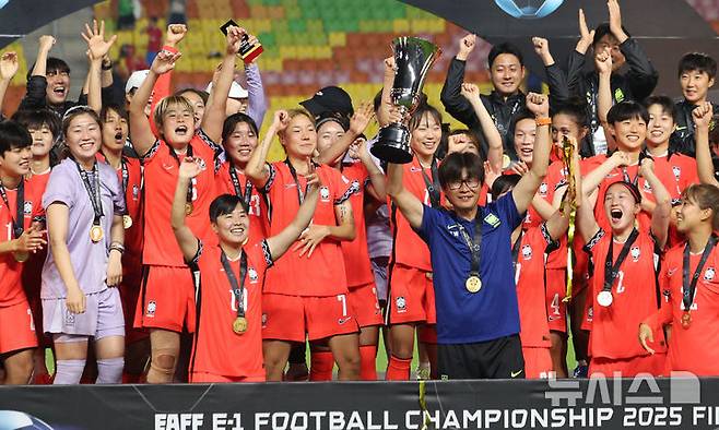 [수원=뉴시스] 김선웅 기자 = 16일 경기 수원시 수원월드컵경기장에서 열린 2025 동아시아축구연맹(EAFF) E-1 챔피언십(동아시안컵) 여자부 시상식에서 우승국 대한민국 대표팀 신상우 감독과 선수들이 트로피를 들고 기뻐하고 있다. 2025.07.16. mangusta@newsis.com