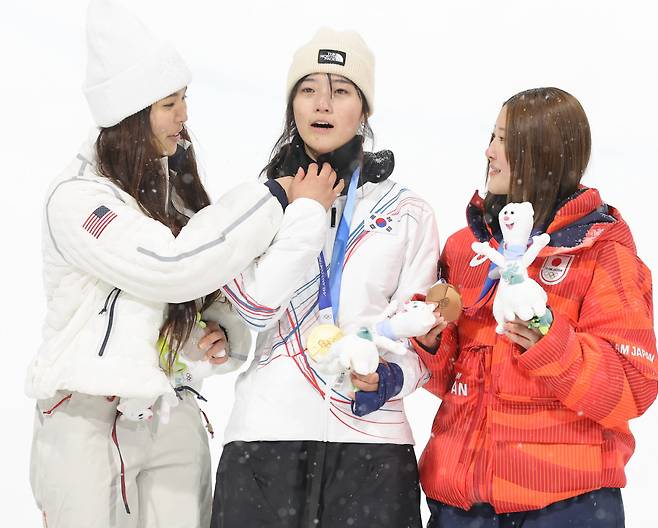 ▲ 클로이 킴(왼쪽)이 최가온(가운데)의 얼굴을 가리고 있던 넥워머를 내리고 있다. ⓒ연합뉴스