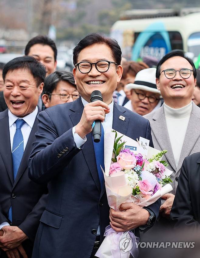 소나무당 송영길 대표, '돈봉투 의혹' 항소심 무죄 판결 (서울=연합뉴스) 더불어민주당 전당대회 '돈봉투 살포' 의혹과 불법 정치자금 수수 혐의로 재판에 넘겨진 소나무당 송영길 대표가 13일 서초구 서울고등법원에서 열린 2심 선고 공판에서 무죄를 선고 받은 뒤 축하 꽃다발을 받고 입장을 밝히고 있다. 2026.2.13 [소나무당 제공. 재판매 및 DB 금지] photo@yna.co.kr