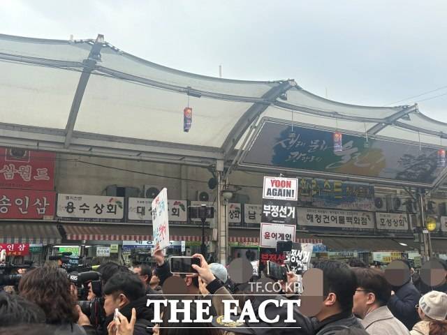 장동혁 국민의힘 대표가 대구 중구 서문시장을 찾은 11일 일부 지지자들이 "YOON AGAIN!" "부정선거" "윤어게인" 문구가 적힌 팻말을 들고 있다. /김수민 기자