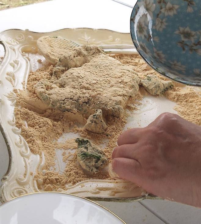 찹쌀밥과 쑥을 잘 섞어서 치댄 뒤 콩고물을 묻혀 썰고 있다. 칼 보다는 접시날로 떡을 써는 게 좋다.