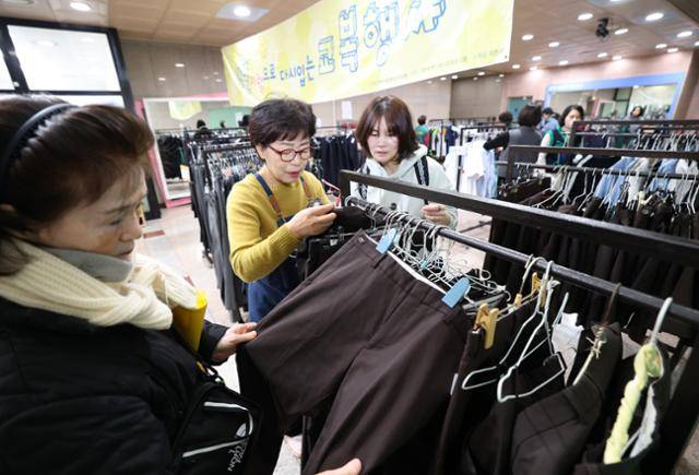 5일 경기 과천시 과천시민회관 녹색가게 앞 로비에서 열린 제29회 '알뜰사랑으로 물려 입는 교복' 행사에서 학부모들이 기부된 과천시 관내 중·고등학교 교복을 구매하고 있다. 뉴스1