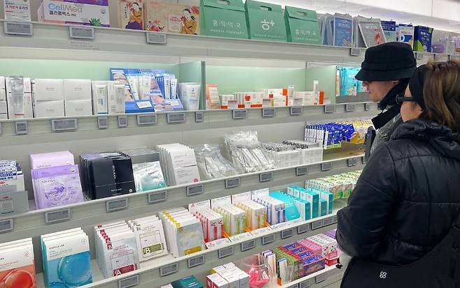 더마코스메틱 화장품이 진열된 홍익약국의 매대. 외국인 관광객이 제품을 둘러보고 있다. 김세린 기자