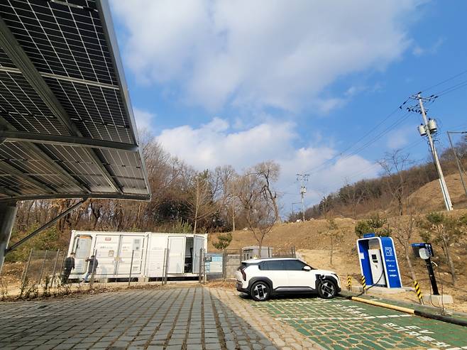 경기도 의왕시 무민공원에 조성된 LS일렉트릭 마이크로그리드 단지 전경. 주차장 태양광 패널과 전기차 충전소 사이로 저장장치 및 통제실이 있다. /사진=권다희 기자