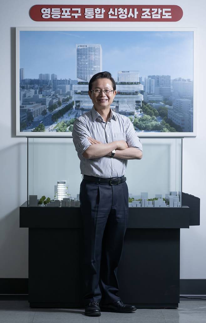 최호권 서울 영등포구청장이 최근 헤럴드경제와 인터뷰에 앞서 신청사 조감도를 배경으로 포즈를 취하고 있다. 당산근린공원 부지에 들어서는 신청사는 2030년 준공을 목표로 하고 있다. 임세준 기자