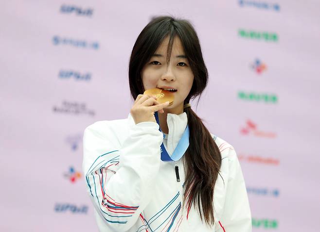 2026 밀라노ㆍ코르티나담페초 동계올림픽 스노보드 여자 하프파이프에서 금메달을 차지한 최가온이 14일(현지 시각) 이탈리아 밀라노 코리아하우스에서 열린 대한체육회 공식 기자회견에서 금메달을 깨물어 보고 있다. [연합]