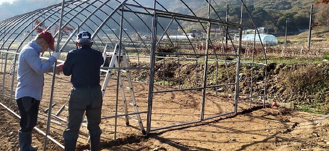 문을 달고 비닐을 끼울 패드 등 부속품을 노인회장님과 함께 조립하고 있다.