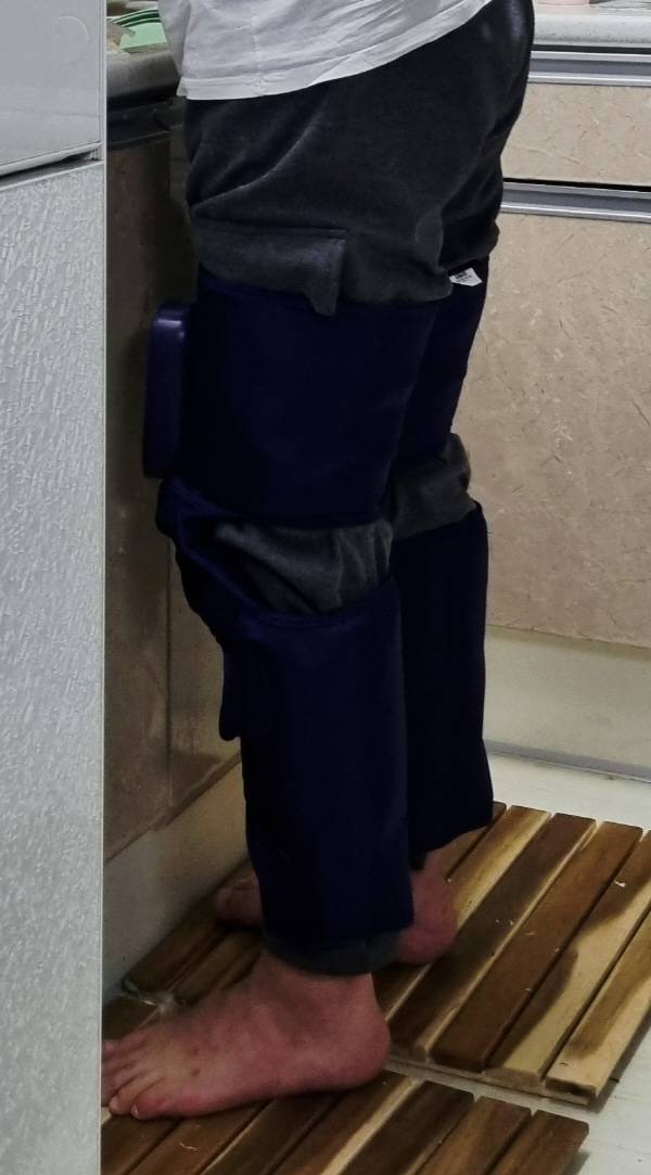 허벅지 마사지기를 착용하고 설거지를 하고 있다. 정옥재 기자