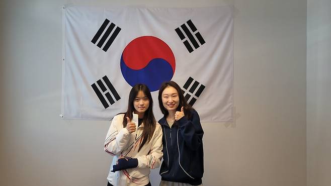 스노보드 최가온(왼쪽)과 쇼트트랙 최민정이 15일(한국시간) 오전 밀라노 선수촌에서 만나 기념촬영을 했다. 최가온은 자신의 금메달을 보여주며 최민정에게 ‘금빛 기운’을 전달했다. 사진제공ㅣ대한체육회