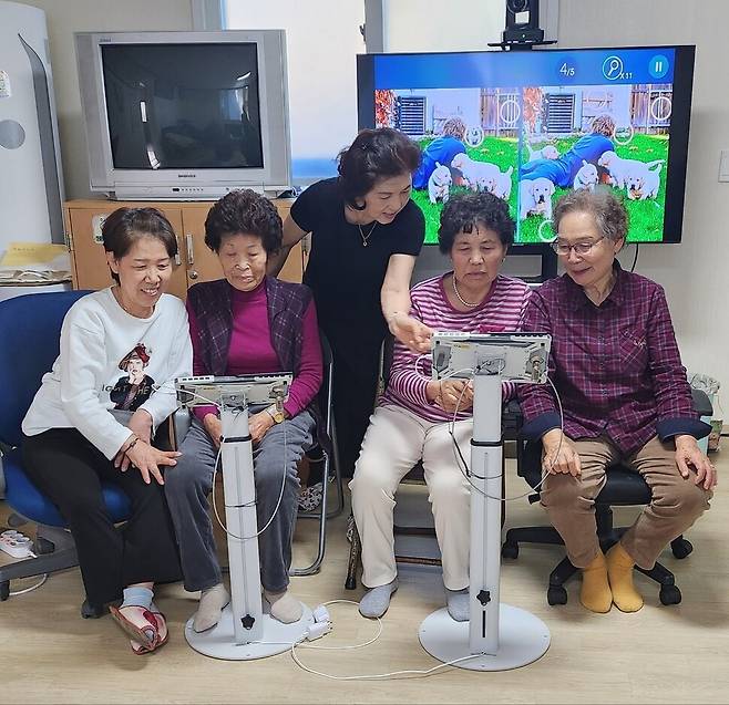 이영순 스마트 매니저(뒷줄 중앙)가 대전 유성구 외삼1통경로당에서 키오스크 사용법을 어르신들에게 설명하고 있다. 유성구노인복지관 제공