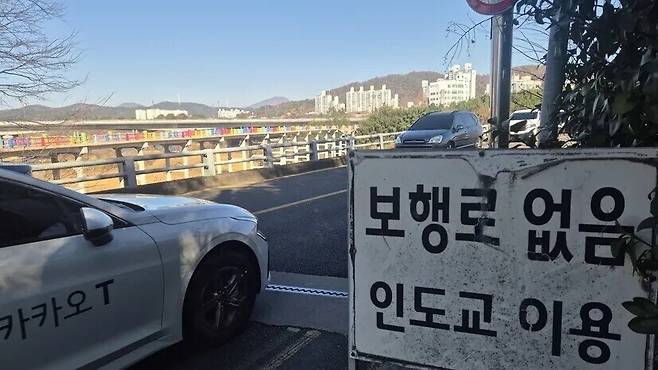 울산 남구 삼호교 들머리에 보행로가 없으니 인도교(옛 삼호교)를 이용하라는 안내판이 붙어 있다. 다리 너머로 상판이 무너진 무지개색 난간의 옛 삼호교가 보인다. 한겨레 주성미 기자