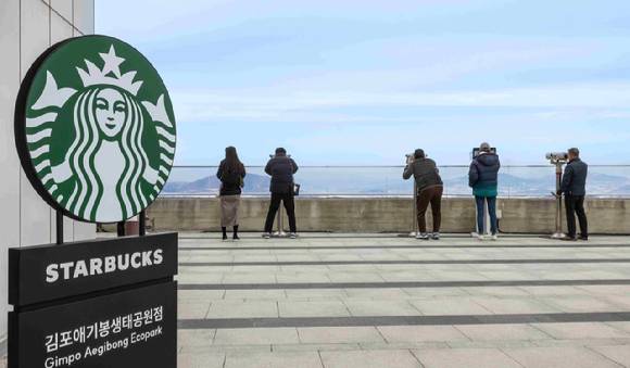 스타벅스 김포 애기봉생태공원점을 방문한 고객들이 망원경을 통해  북한 황해도 개풍군 일대를 조망하고 있는 모습. [사진=스타벅스 제공]