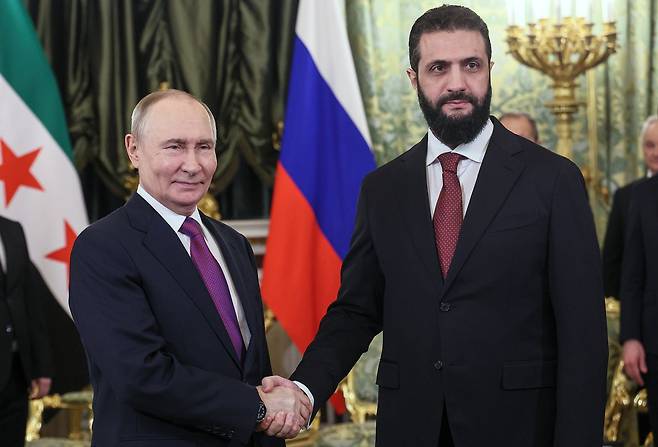 지난달 28일 러시아 모스크바를 방문한 아메드 알샤라 시리아 임시 대통령(오른쪽)이 블라디미르 푸틴 러시아 대통령을 만나 악수하고 있다. AP=연합뉴스