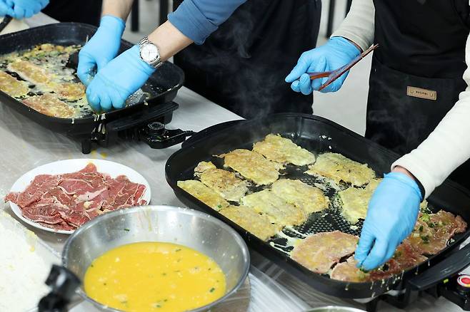 설 연휴를 하루 앞둔 지난 13일 오전 광주 동구 계림동 들랑날랑센터에서 쪽방촌 주민들이 모여 명절음식을 만들고 있다. 뉴스1