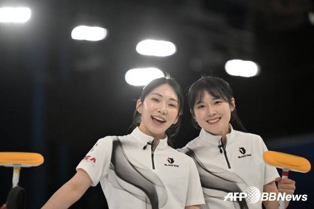 한국 여자 컬링 대표팀 경기도청 김수지(왼쪽)와 설예은이 13일(현지 시간) 이탈리아 코르티나담페초의 코르티나 컬링 올림픽 스타디움에서 열린 2026 밀라노·코르티나 동계올림픽 컬링 라운드로빈 3차전에서 영국을 꺾고 환하게 웃고 있다. /AFPBBNews=뉴스1