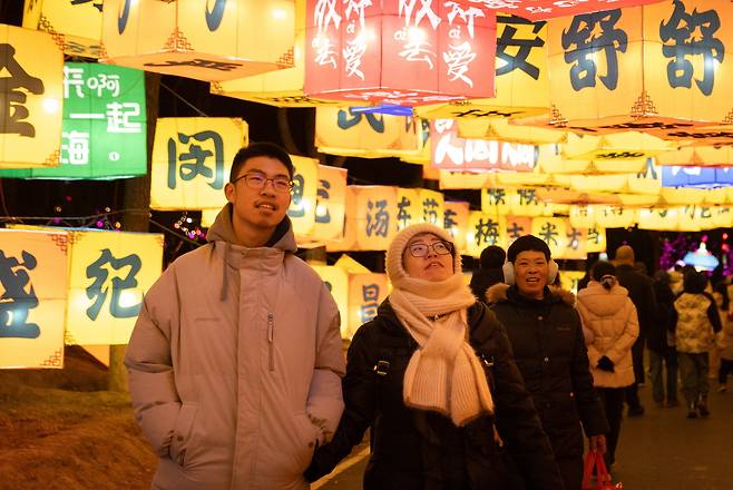 15일(현지시간) 중국 베이징에서 시민들이 설(춘절)을 앞두고 설치된 화려한 조명 아래를 거닐고 있다. EPA연합
