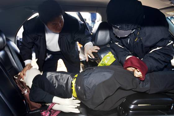 Kang Ho-sun, right, re-enacts a scene of murdering a female college student in his car in Hwaseong, Gyeonggi, on Jan. 27, 2009. [JOINT PRESS CORPS]