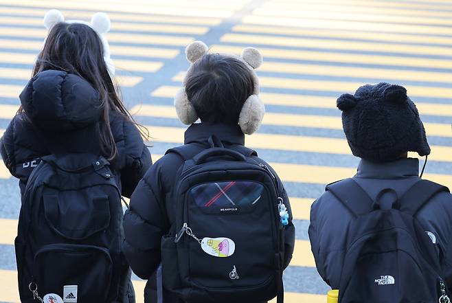 수원시 한 초등학교 앞에서 방한 귀마개를 한 어린이들이 등교하고 있다. [연합]