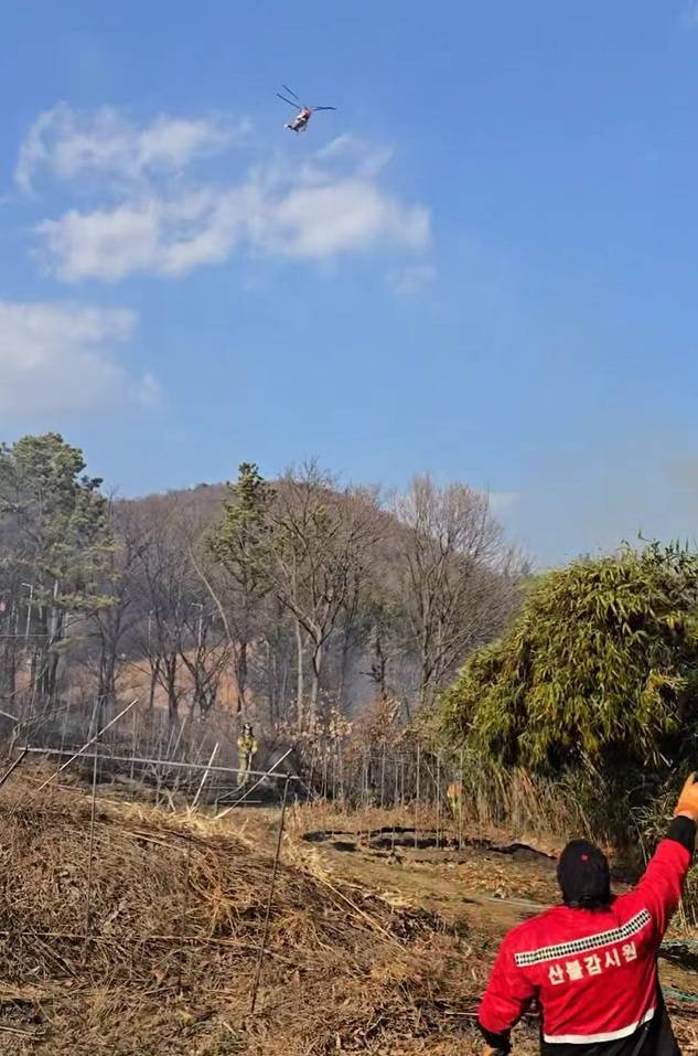 18일 오후 울산 북구 천곡동 순금산 자락에서 발생한 산불을 진화하기 위해 산림 당국 헬기가 물을 뿌리며 공중 진화 작업을 벌이고 있다. 울산소방본부 제공