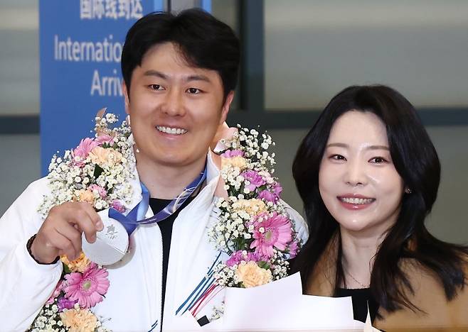 2026 밀라노·코르티나담페초 동계 올림픽에서 한국에 400번째 올림픽 메달을 안겨준 스노보드 김상겸이 지난 10일 오전 인천국제공항을 통해 귀국하며 은메달을 들어 보이고 있다. 오른쪽은 아내 박한솔 씨. 뉴스1