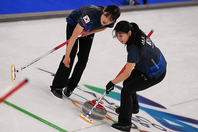 한국 여자 컬링 대표팀 설예은과 김민지가 지난 16일(현지 시간) 이탈리아 코르티나담페초의 코르티나 컬링 올림픽 스타디움에서 열린 2026 밀라노·코르티나 동계올림픽 컬링 라운드로빈 6차전 중국과 경기하고 있다. 한국이 10-9로 재역전승을 거두고 4승2패를 기록했다. /AP=뉴시스