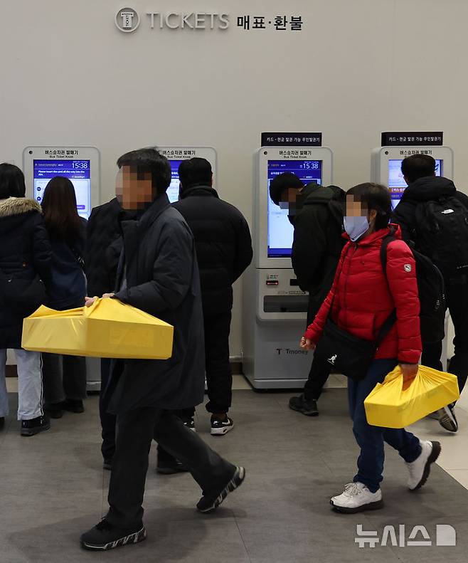 [서울=뉴시스] 최진석 기자 = 설 연휴를 하루 앞둔 13일 서울 서초구 서울고속버스터미널에서 역귀성객들이 승차권을 구입하는 귀성객 앞을 지나고 있다. 2026.02.13. myjs@newsis.com