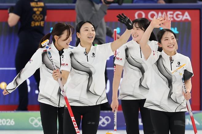 한국 여자 컬링 대표팀 선수들이 18일(한국시간) 이탈리아 코르티나담페초 컬링 올림픽 스타디움에서 열린 컬링 여자 라운드로빈 스웨덴과의 경기에서 8-3으로 승리한 뒤 환호하는 관중들에게 손을 흔들어 인사하고 있다. 연합뉴스