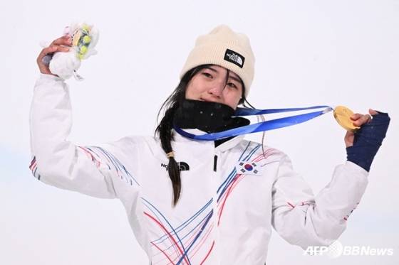 스노보드 최가온이 13일 이탈리아 리비뇨 스노파크에서 열린 2026 밀라노·코르티나담페초 동계올림픽 스노보드 여자 하프파이프 결선에서 90.25점으로 88.00점의 클로이 김(미국)을 제치고 금메달을 목에 걸고 포즈를 취하고 있다. /AFPBBNews=뉴스1